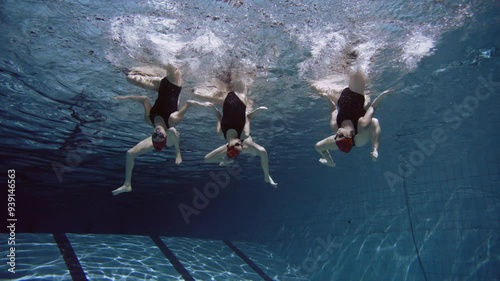 Underwater shot of six women practicing synchronized swimming