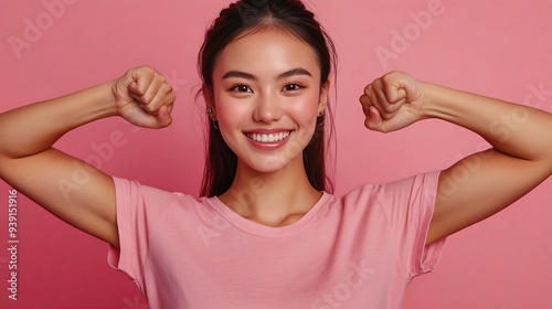 Strong powerful Asian woman with dark combed hair toothy smile raises arms and shows biceps has piercing in ear wears casual rosy t shirt models against pink background Look at my musc : Generative AI photo