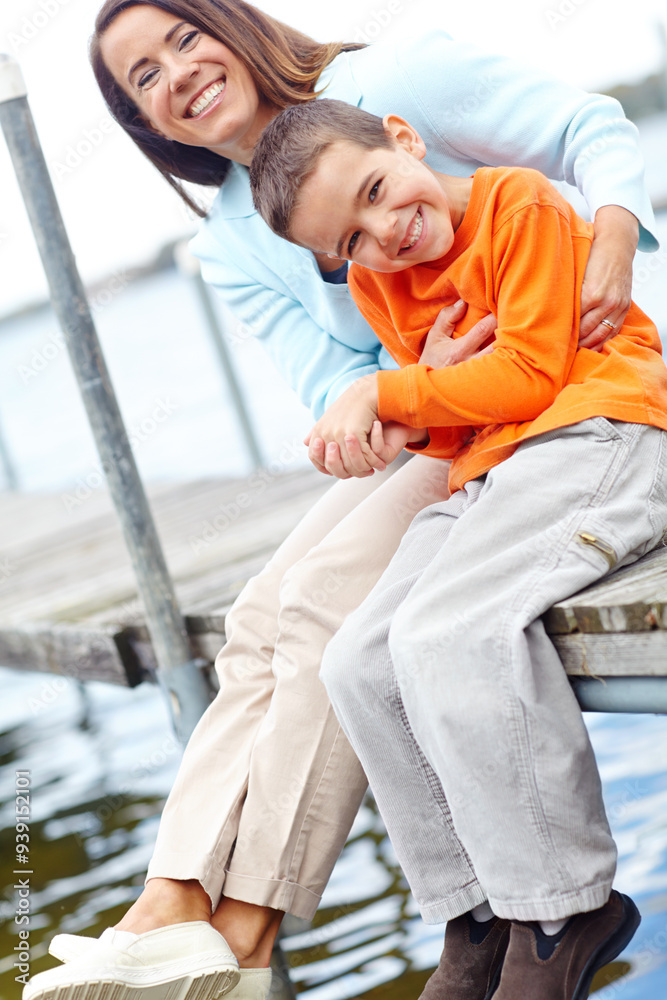 Happy, mother and kid on dock for portrait, love and tickling on harbour on vacation. Family, mom and child at ocean for holiday, bonding and relationship development with trust and support in Canada Happy, mother and kid on dock for portrait, love and tickling on harbour on vacation. Family, mom and child at ocean for holiday, bonding and relationship development with trust and support in Canada