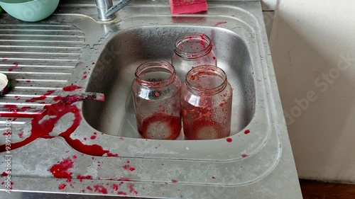 Empty jam jars with jam residue in the kitchen sink photo