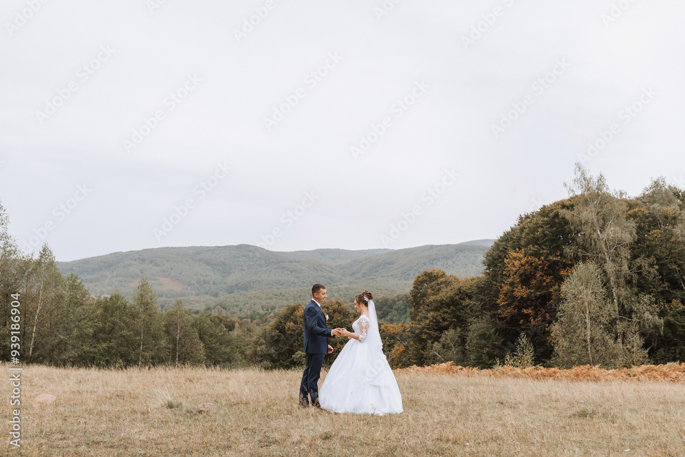 A bride and groom stand in a field, with the bride wearing a white dress and the groom wearing a suit. The scene is peaceful and serene, with the couple looking into each other's eyes A bride and groom stand in a field, with the bride wearing a white dress and the groom wearing a suit. The scene is peaceful and serene, with the couple looking into each other's eyes
