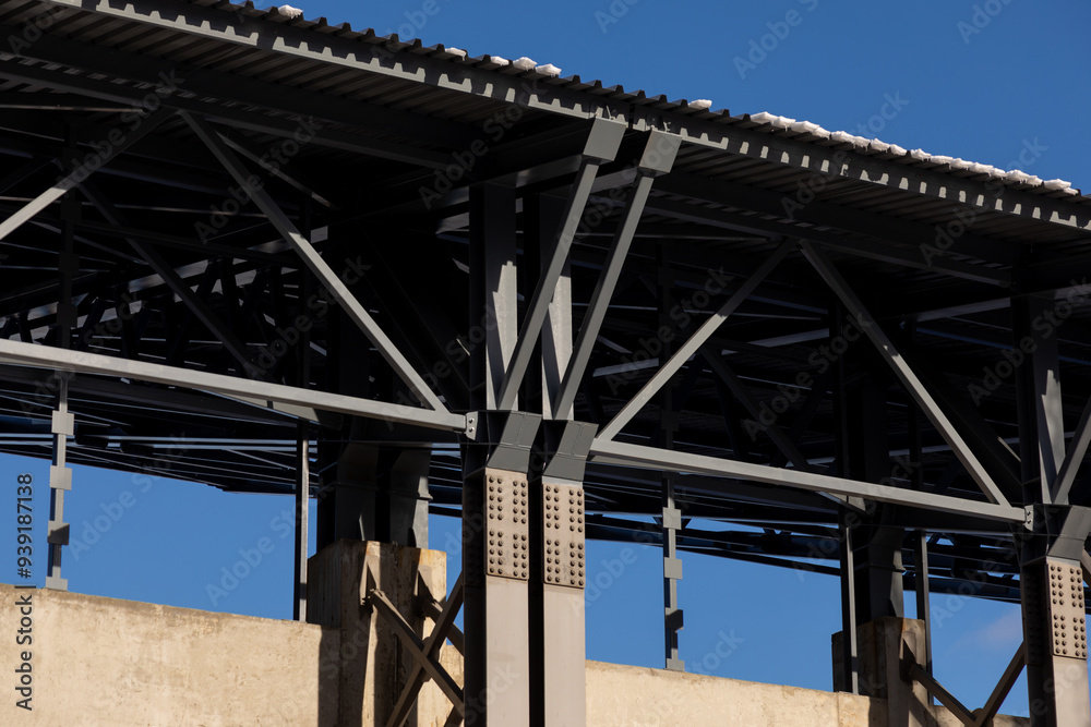 Obraz premium Concrete pillars with bolted connections of metal support structures and roof of industrial building