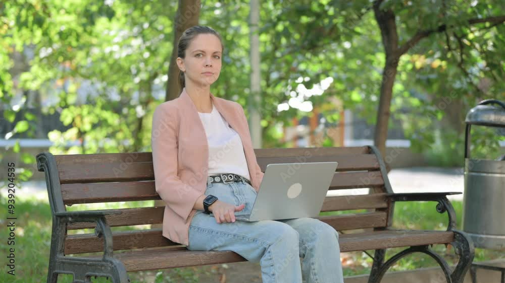 Young Woman Looking at Camera while Using Laptop Outdoor Young Woman Looking at Camera while Using Laptop Outdoor