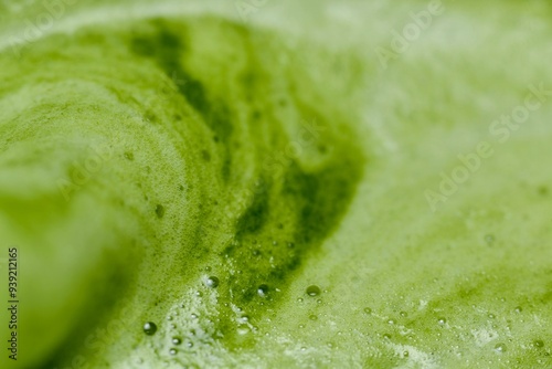 A close-up image of green tea with a smooth, frothy texture. The vibrant green color and visible air bubbles on the surface highlight the Dispersion of air bubbles