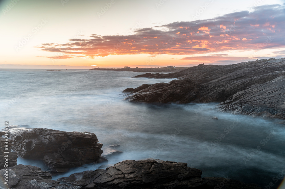 Obraz premium Blick von der rauen steilküste mit seinen felsen auf quiberon in frankreich auf den sonnenuntergang über dem atalantik