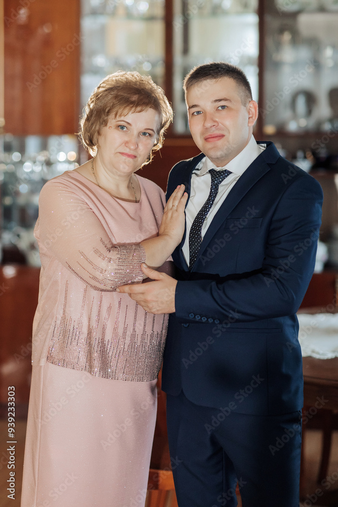 A woman and a man are posing for a picture. The woman is wearing a pink ...