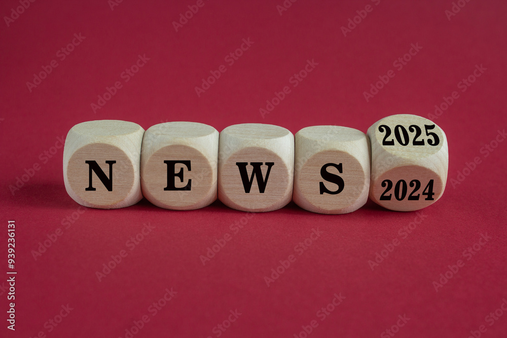 2025 News new year symbol. Turned a wooden cube and changes words News 2024 to News 2025. Beautiful red background. Business 2025 news new year concept. 2025 News new year symbol. Turned a wooden cube and changes words News 2024 to News 2025. Beautiful red background. Business 2025 news new year concept.