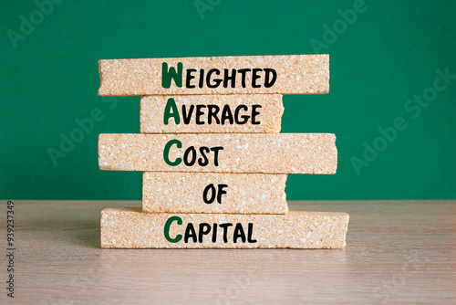 WACC- weighted average cost of capital symbol. Concept words Weighted Average Cost Of Capital on brick blocks. Beautiful green background, wooden table. Business concept. photo