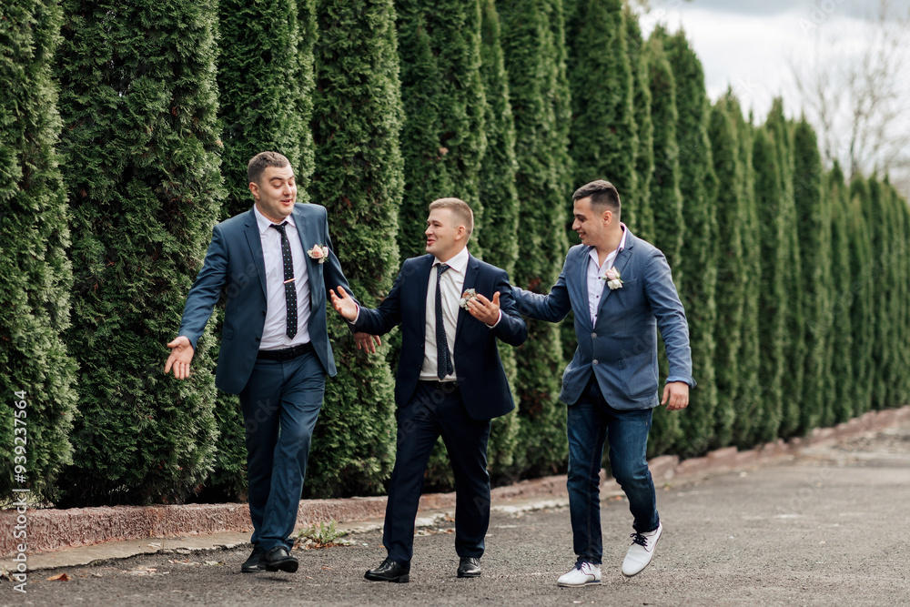 Three men in suits are walking down a street, one of them holding hands with the other two Three men in suits are walking down a street, one of them holding hands with the other two