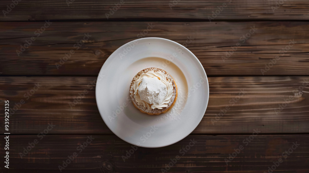 Delicious pancake with whipped cream is waiting on a white plate on a wooden table