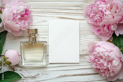 Top View Elegant Peonies with Perfume. Top view of elegant pink peonies, perfume bottle, and blank card on wooden background, ideal for events.