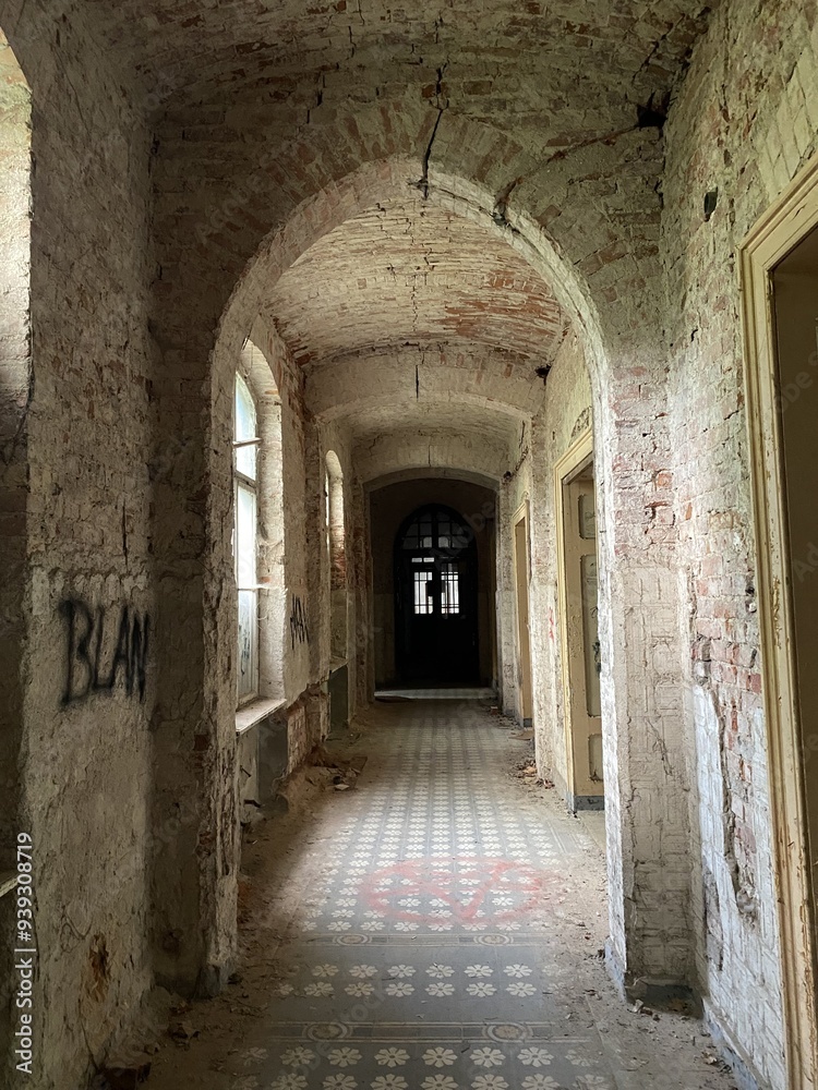 An eerie, abandoned hallway with brick walls, arched doorways, and graffiti, illuminated by natural light, showcasing wear and historical decay. An eerie, abandoned hallway with brick walls, arched doorways, and graffiti, illuminated by natural light, showcasing wear and historical decay.