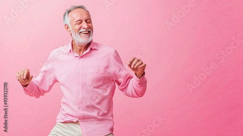 Joyful Elderly Man Dancing Against Pink Background in Studio