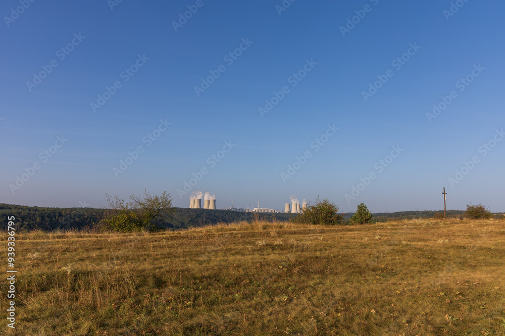 Dukovany nuclear power plant in the Czech Republic, Europe. Smoke cooling towers. There are clouds in the sky. In the foreground is the nature of the Highlands