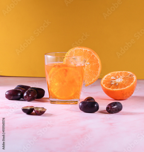 A Fresh orange and grapes Juice, Fresh Color Juices, Healthy drink on Tiles Marvel, Tropical juice, mix fruits orange and Grapes, yellow background, cutting orange and grapes fruites photo