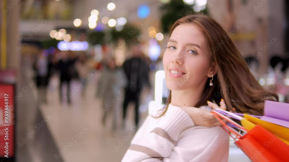 A young woman, filled with joy, proudly displaying her shopping bags in a colorful and vibrant shopping mall A young woman, filled with joy, proudly displaying her shopping bags in a colorful and vibrant shopping mall
