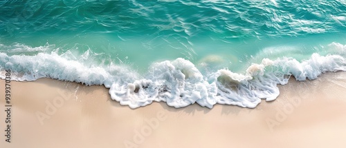 Obraz na płótnie Aerial view of a turquoise ocean wave gently crashing onto a sandy beach, creating a serene and tranquil seaside landscape. w salonie