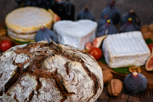 Selection of French cheeses from Normandy, AOP, Livarot, Neufchatel, Pont l'eveque, Rye bread, figs, walnuts, grapes, elderberry gelee. High quality photo photo