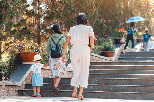 Canvas Print Back view of happiness woman in white clothes walking up stairs outdoors in park