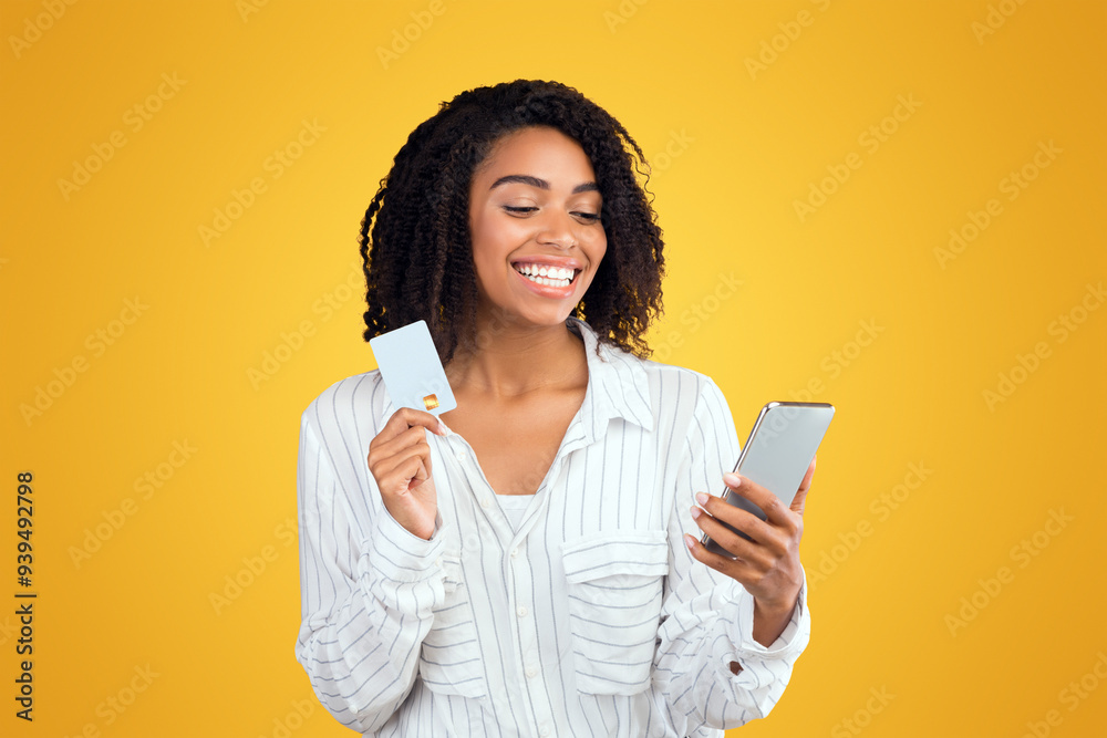 © Prostock-studio - Online Shopping. Afro girl holding credit card, using smartphone purchasing goods in internet © Prostock-studio - Online Shopping. Afro girl holding credit card, using smartphone purchasing goods in internet