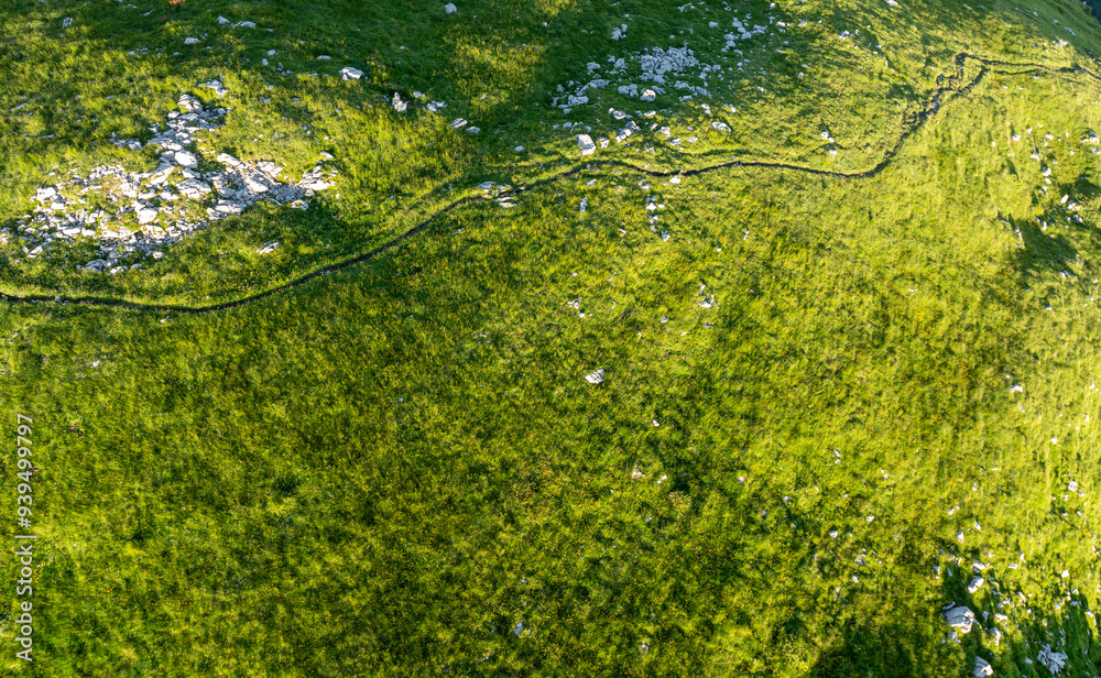 Aerial view of mountains with grass and rocks in Switzerland. Hiking in tranquil nature. Background with alpine pattern. Aerial view of mountains with grass and rocks in Switzerland. Hiking in tranquil nature. Background with alpine pattern.