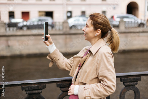 Close-up portrait of female tourist, taking photos in the city on a walk. photo