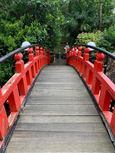 Vászonkép Red japanese garden bridge, surrounded by greenery: beautiful perspective