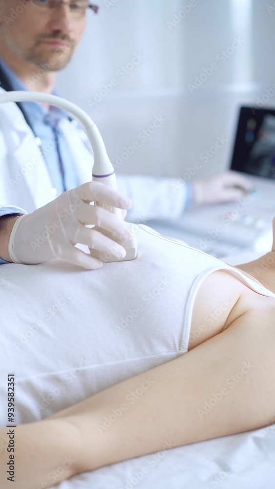 Obraz premium Doctor man wearing white protective gloves is using ultrasound equipment on the breast of a female patient. Mammary gland health. Medicine concept