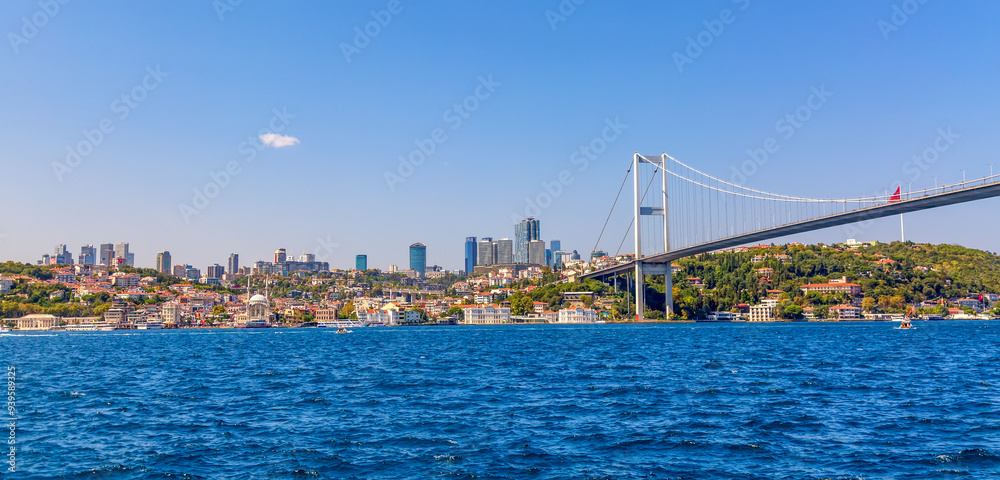 Fototapeta premium Istanbul Bosphorus Bridge or 15th July Martyrs Bridge with Istanbul panorama cityscape during summer sunny day. Istanbul, Turkiye.