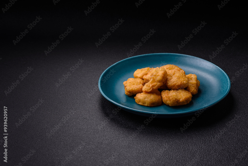 Delicious fresh crispy chicken nuggets on a dark concrete background