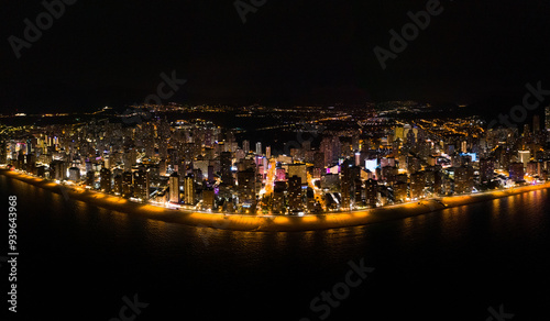 Skyline of Spanish city Benidorm, at night. Street lights. Light reflection in water. Spectacular travel destination in south of Spain, Alicante province.  