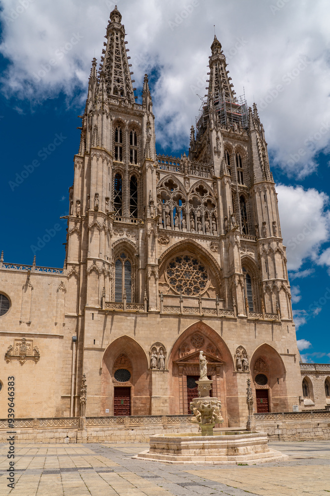 View of Cathedral of Saint Mary of Burgos and Plaza Santa Maria. In the middle of the plaza in Santa Maria Fountain. People visiting the city center. Travel destination. View of Cathedral of Saint Mary of Burgos and Plaza Santa Maria. In the middle of the plaza in Santa Maria Fountain. People visiting the city center. Travel destination.