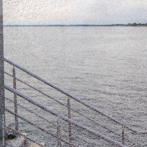 gray water of Baltic Sea through cracked glass photo