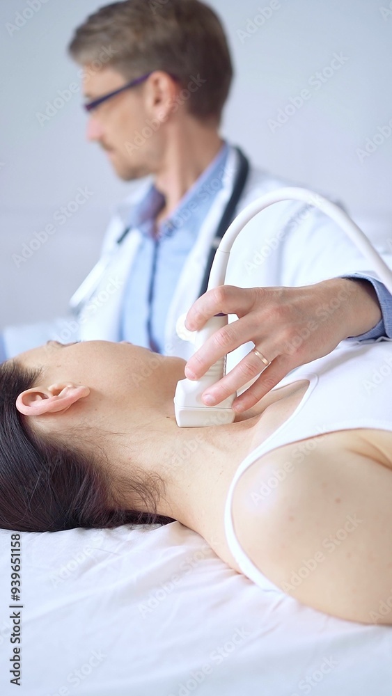 Doctor man using ultrasound equipment on the neck of a patient woman, lying for examination. Medicine concept Doctor man using ultrasound equipment on the neck of a patient woman, lying for examination. Medicine concept