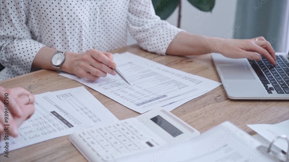 Fototapeta premium Professional female bookkeeper with a colleague are working on business finances. using calculator and laptop. Finance audit and taxes