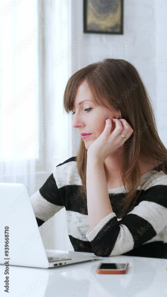 Woman working at desk with laptop computer at home office, thinking, looking busy. 4K video footage. Woman working at desk with laptop computer at home office, thinking, looking busy. 4K video footage.