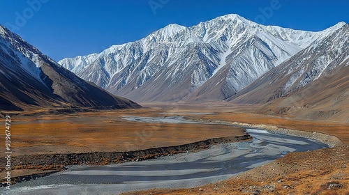   A mountain range with a river in the foreground and snow-capped mountains in the background