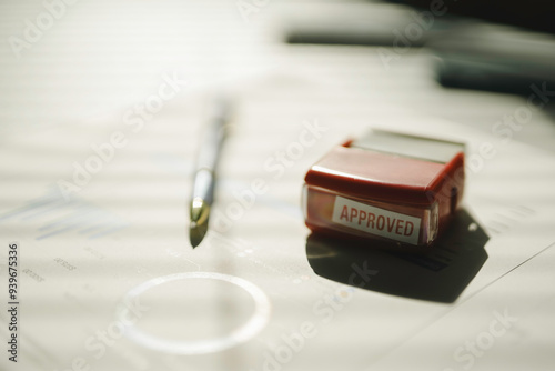 Red approved stamp lying on business documents with charts and graphs waiting for manager approval