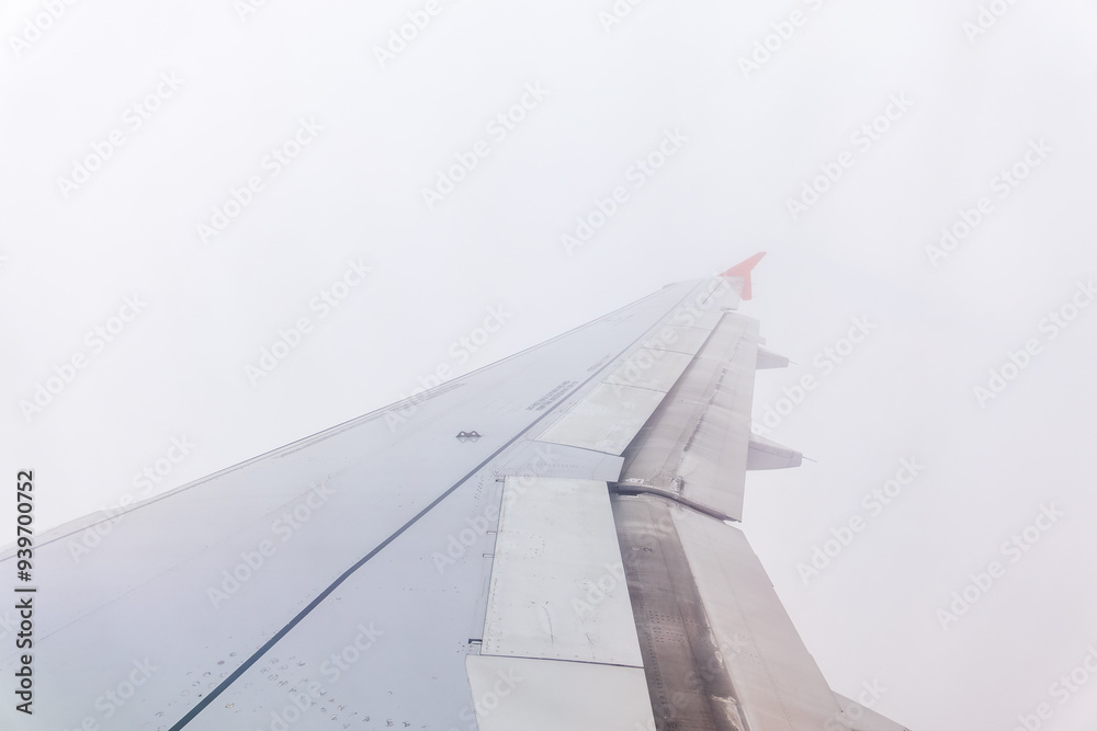 Fototapeta premium View from the airplane window at a beautiful cloudy sky and the airplane wing