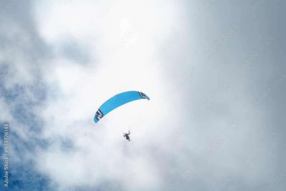 Paraglider soaring high in the sky with a yellow canopy, under a bright sun and scattered clouds. Paraglider soaring high in the sky with a yellow canopy, under a bright sun and scattered clouds.