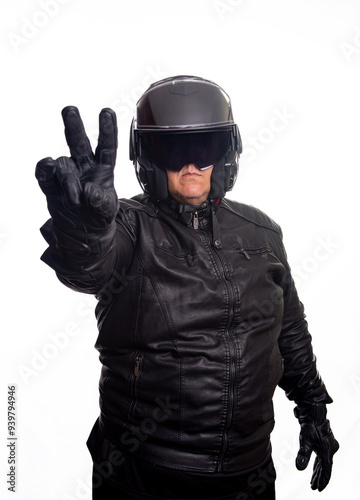 Biker, an adult man in black biker clothing and helmet in front of a white background, selective focus.