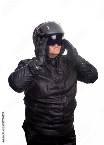 Biker, an adult man in black biker clothing and helmet in front of a white background, selective focus.