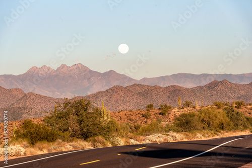 full moon rising over desert mountains