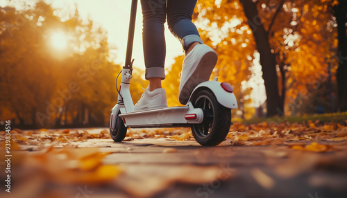 escooter on autumn foliage background , woman riding electric scooter, creative banner, ecological e-scooter transport - Green eco energy concept with zero emission 