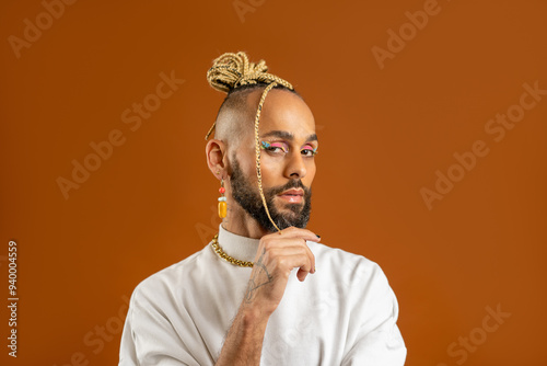 Trendy black latin gay man in white clothes look camera questioning look isolated on orange background studio portrait People lifestyle fashion lgbtq concept. Make up artist photo