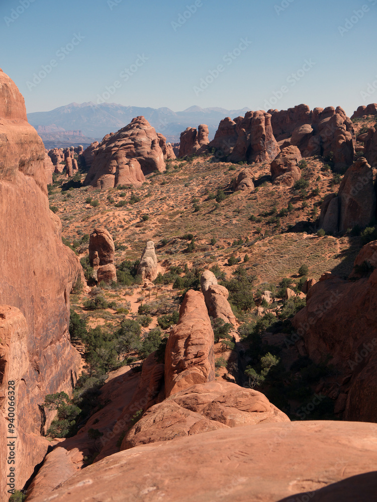 Fototapeta premium Climbing on massive red rock cliff in Arches National Park, Utah