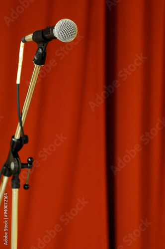 Microphone in front of red curtain.