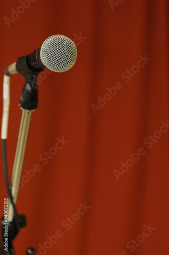 Microphone in front of red curtain.