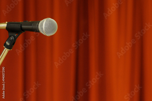 Microphone in front of red curtain.