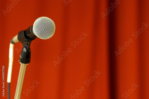 Microphone in front of red curtain.